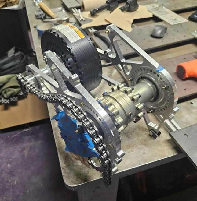 Assembled drivetrain on the bench — motor, differential, mounts, and chain