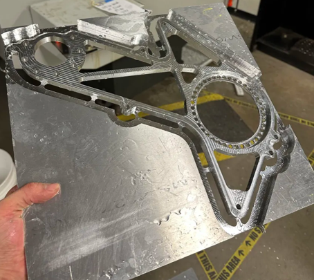 Freshly machined mount, held in hand next to the mill
